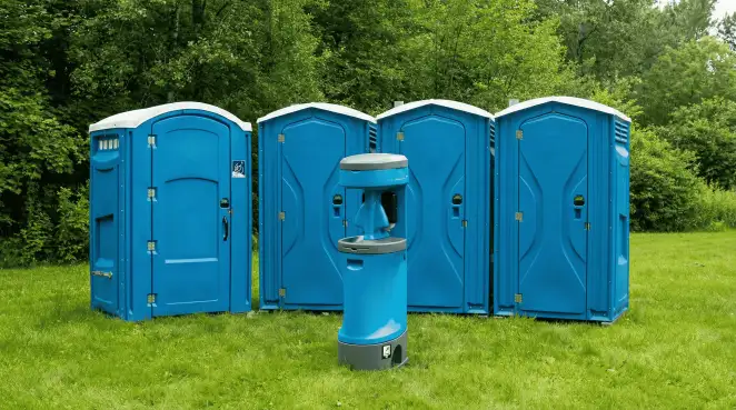 Four blue portable toilets and a matching hand washing station on grass near trees, a common sight at local outdoor events in Glendale, AZ